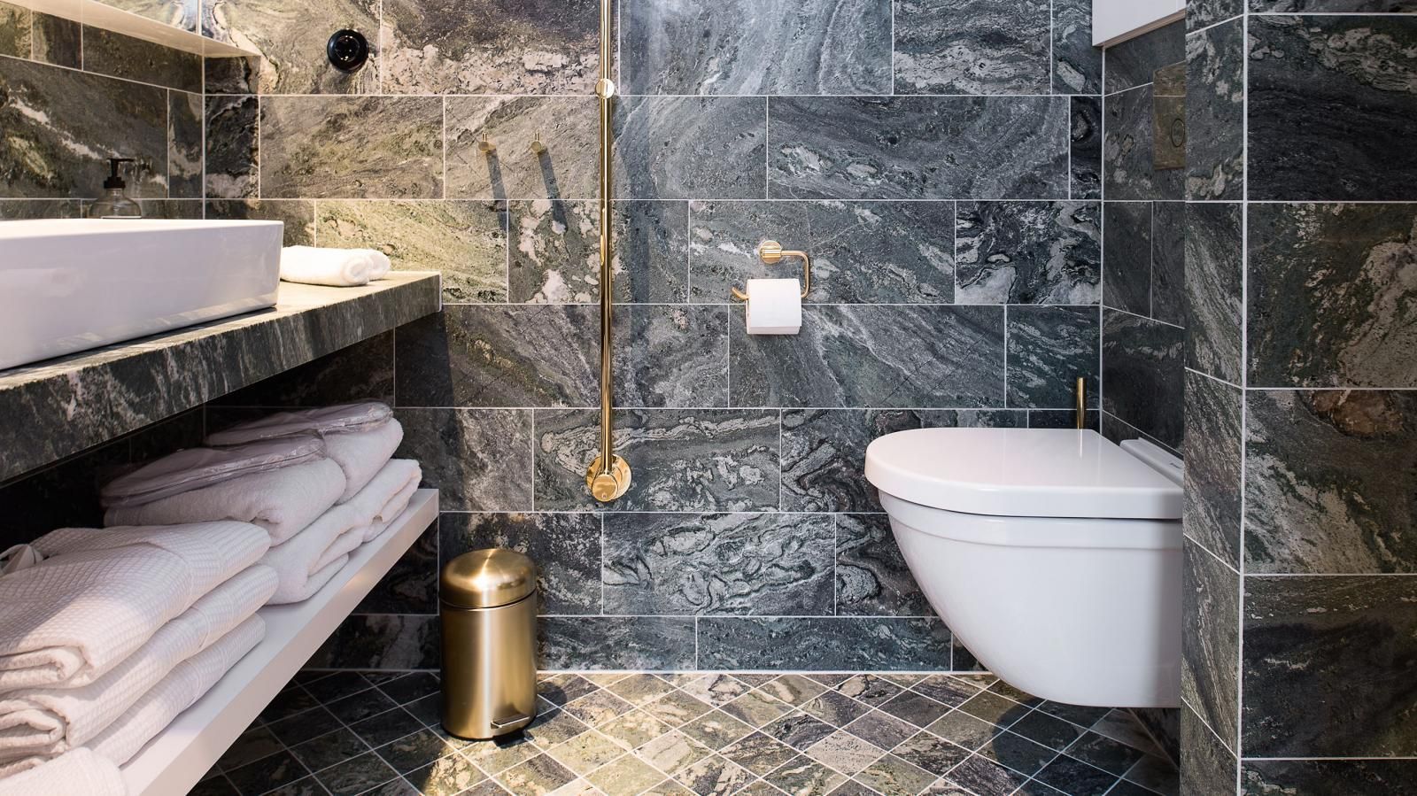 Garden Suite bathroom with a toilet , sink , and trash can.