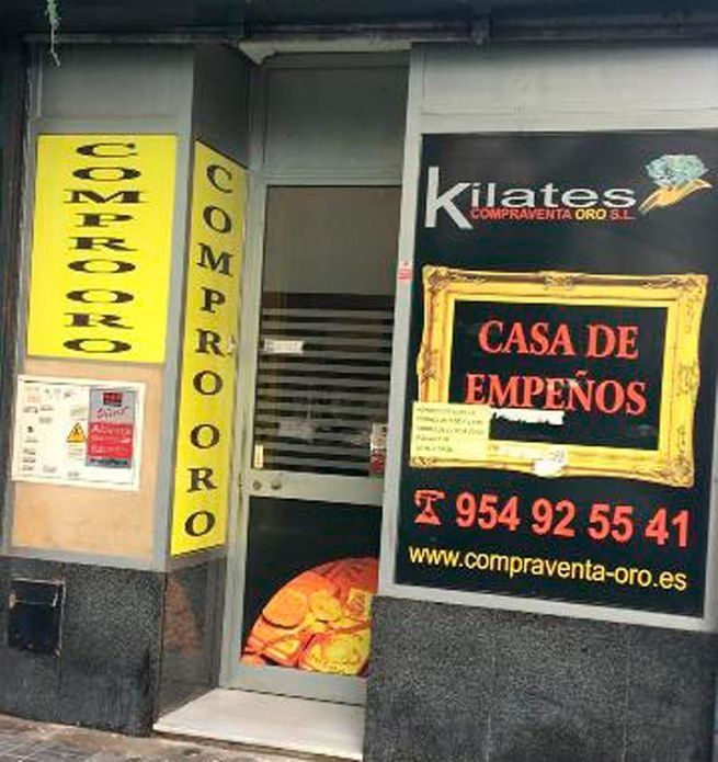 Un escaparate con un cartel que dice casa de empeños