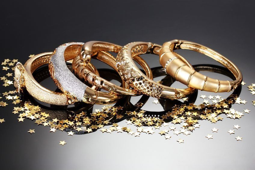 Un montón de pulseras de oro están apiladas una encima de otra.