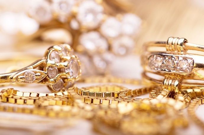 Un primer plano de un montón de joyas de oro sobre una mesa.