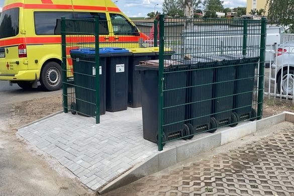 Rettungswagen hinter einem Müllplatz