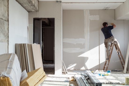 Handwerker misst eine Wand