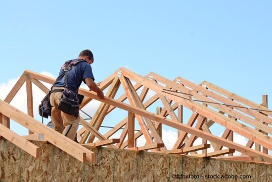 Handwerker verlegt Dachgiebel aus Holz