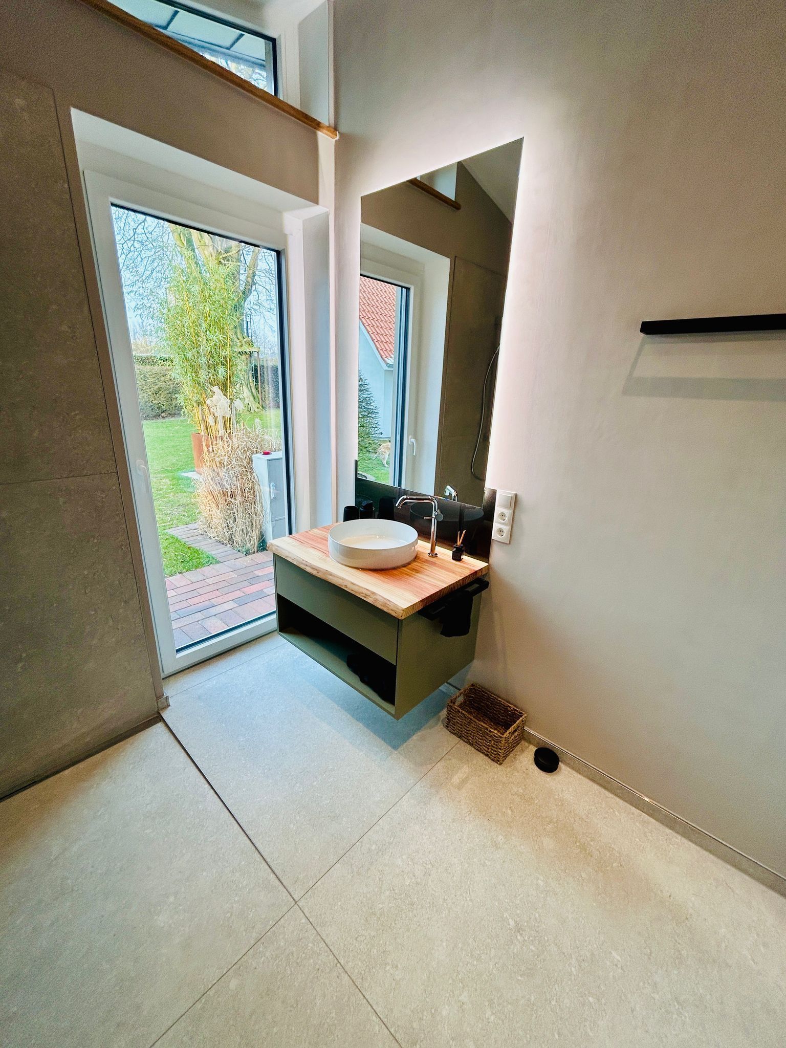 Ein Badezimmer mit Waschbecken, Spiegel und Fenster.