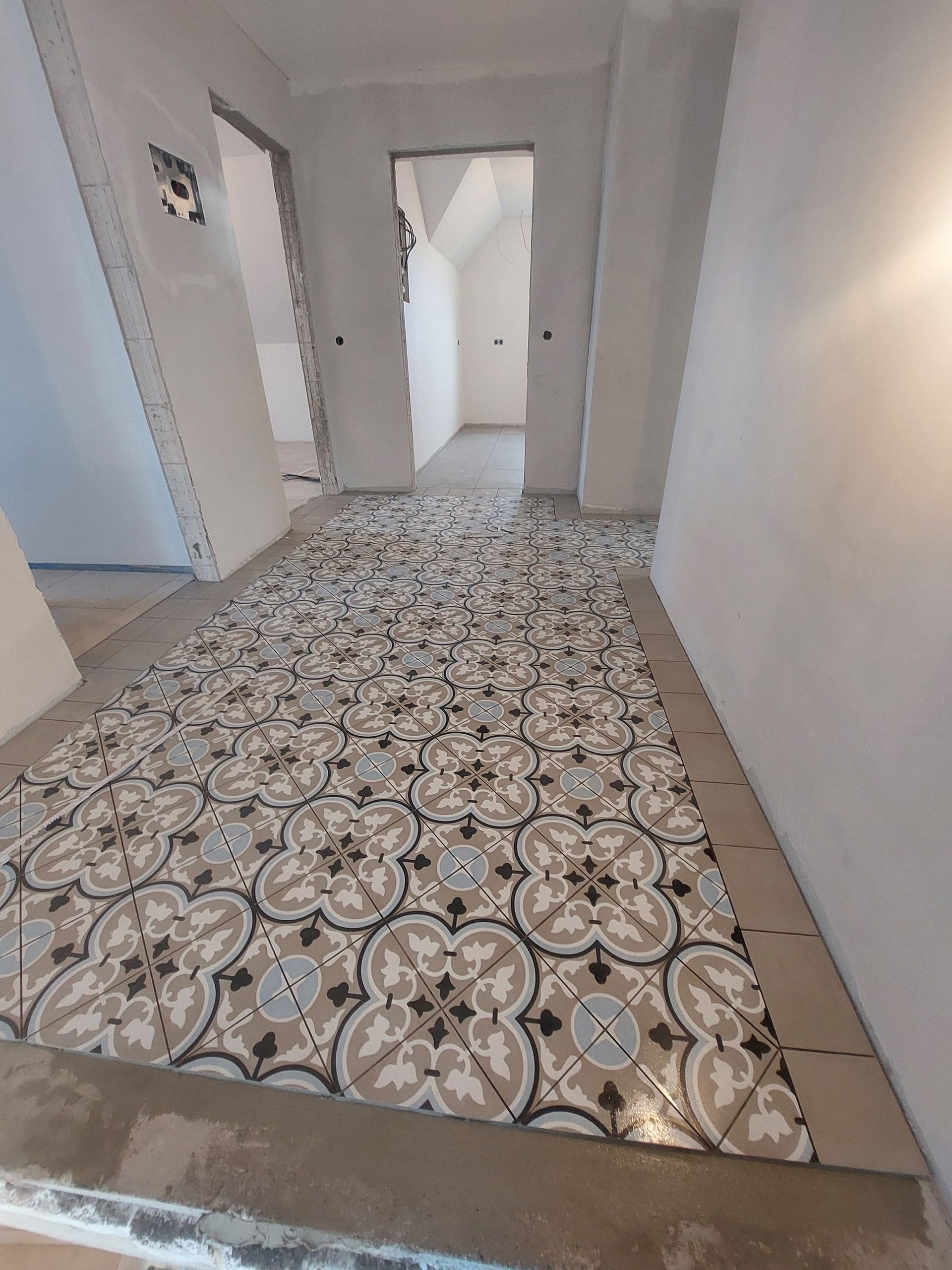 Ein Flur mit gefliestem Boden und einer Tür im Hintergrund.