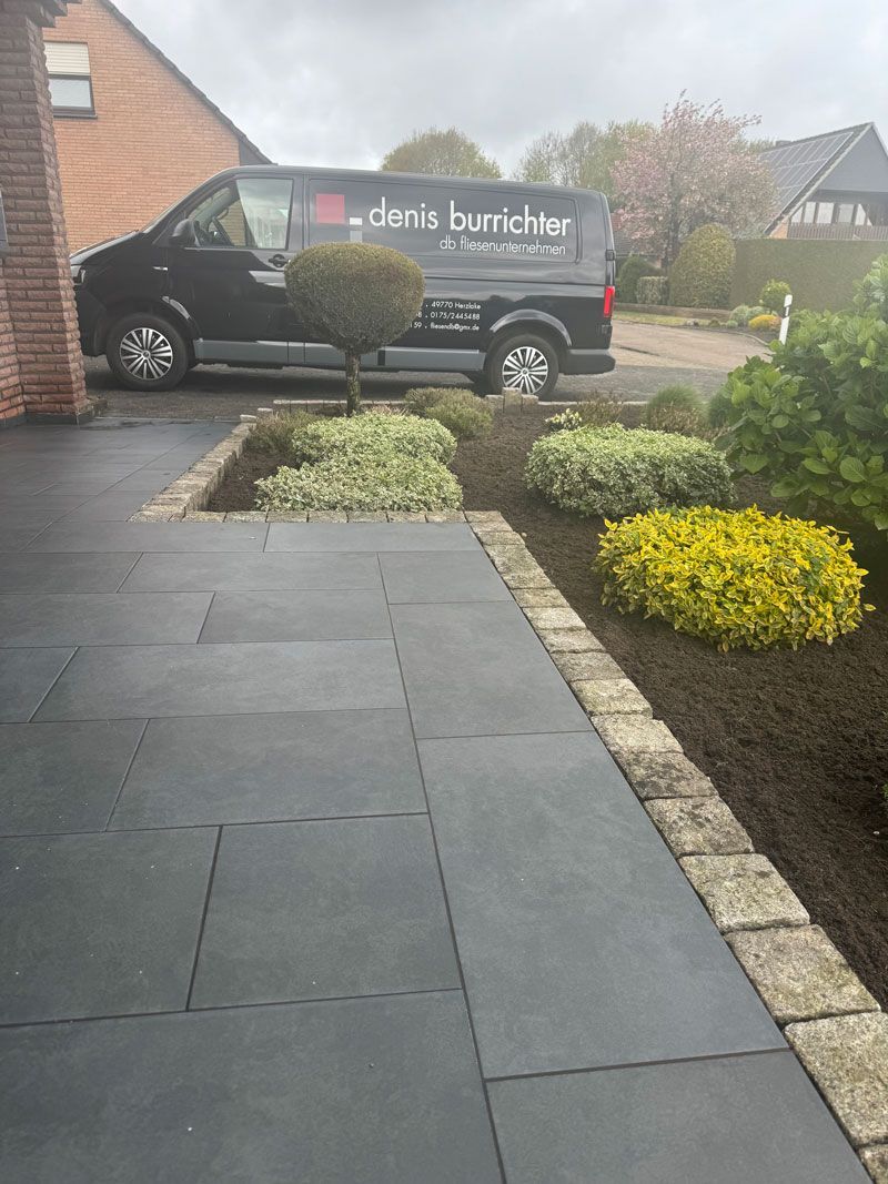 Ein schwarzer Lieferwagen steht in der Einfahrt eines Hauses.