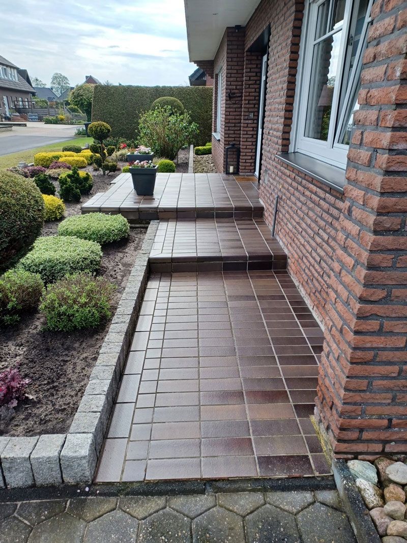 Ein Backsteinhaus mit einem Backsteinweg, der zur Haustür führt.