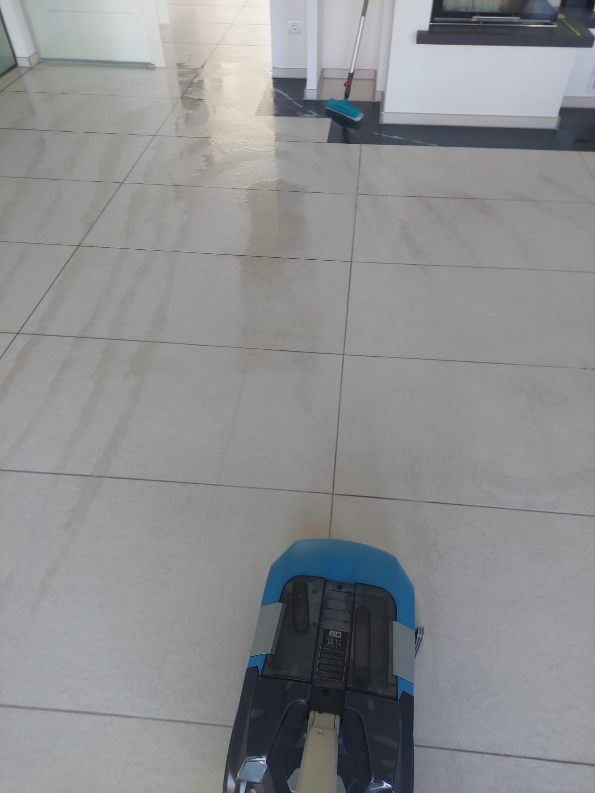 Ein Mopp liegt auf einem gefliesten Boden in einem Raum