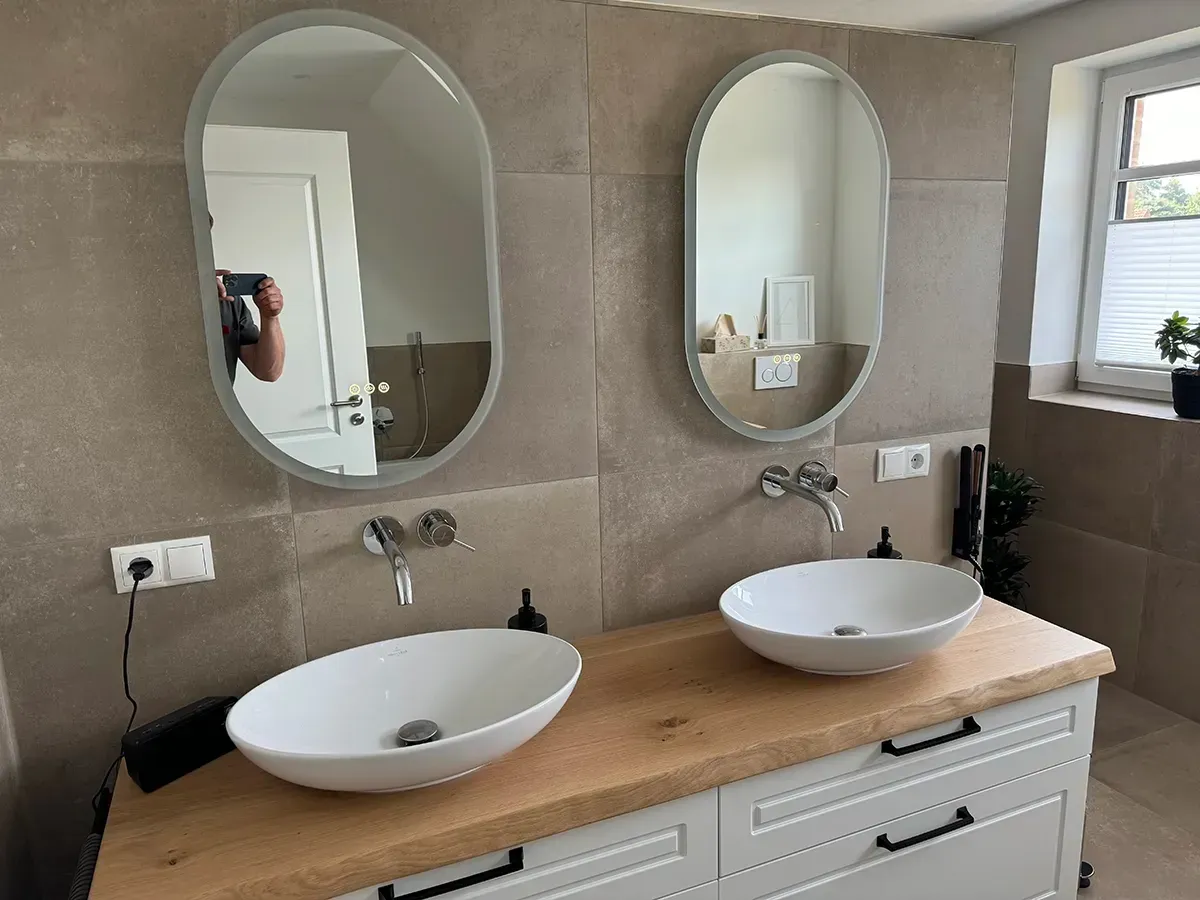 Ein Badezimmer mit zwei Waschbecken und zwei Spiegeln.