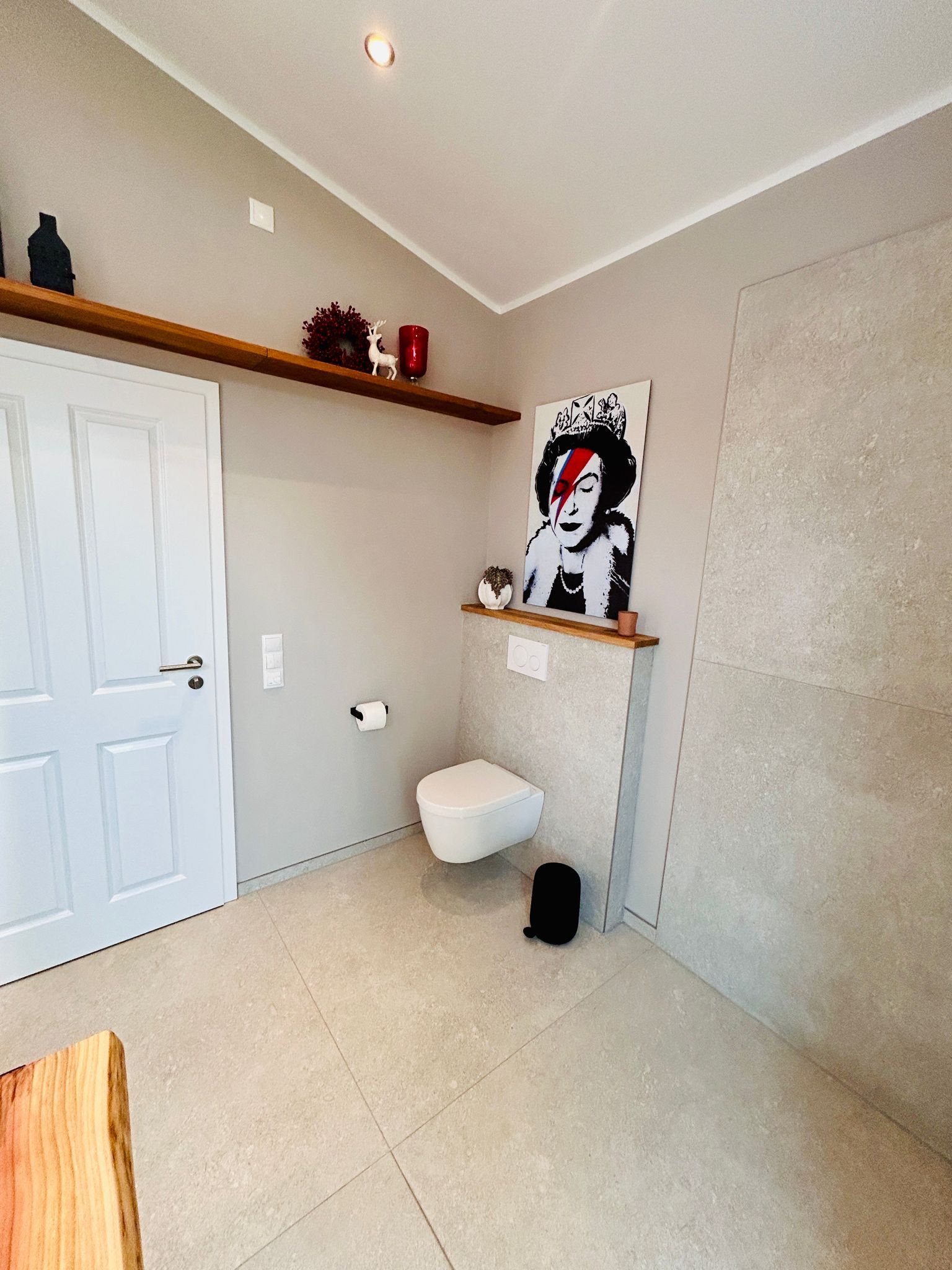 Ein Badezimmer mit Toilette und einem Gemälde an der Wand.