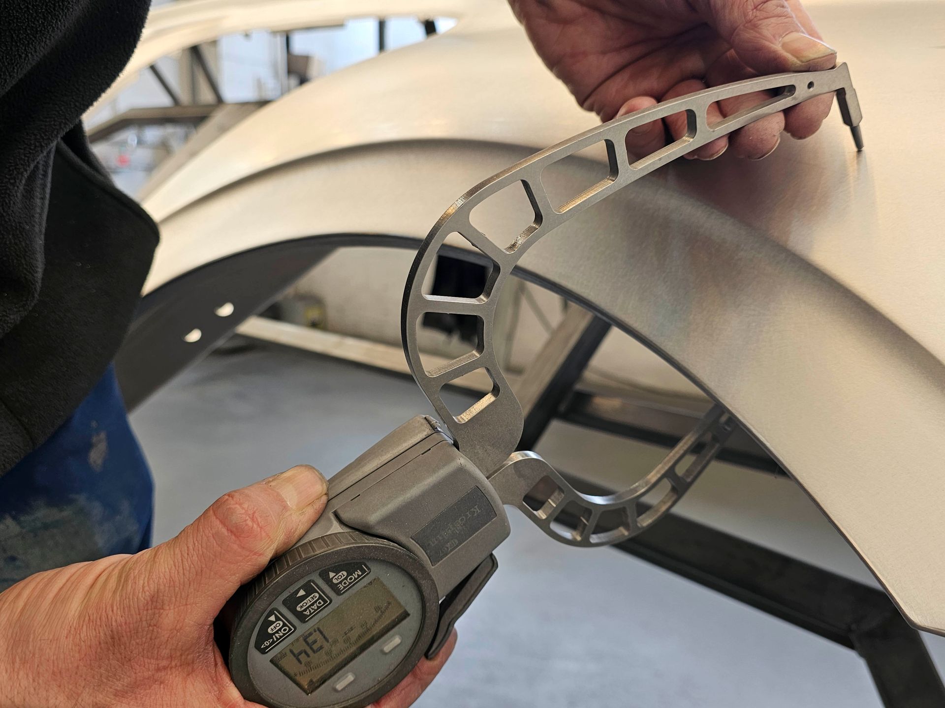 Ein Mann misst ein Stück Metall mit einem digitalen Messschieber