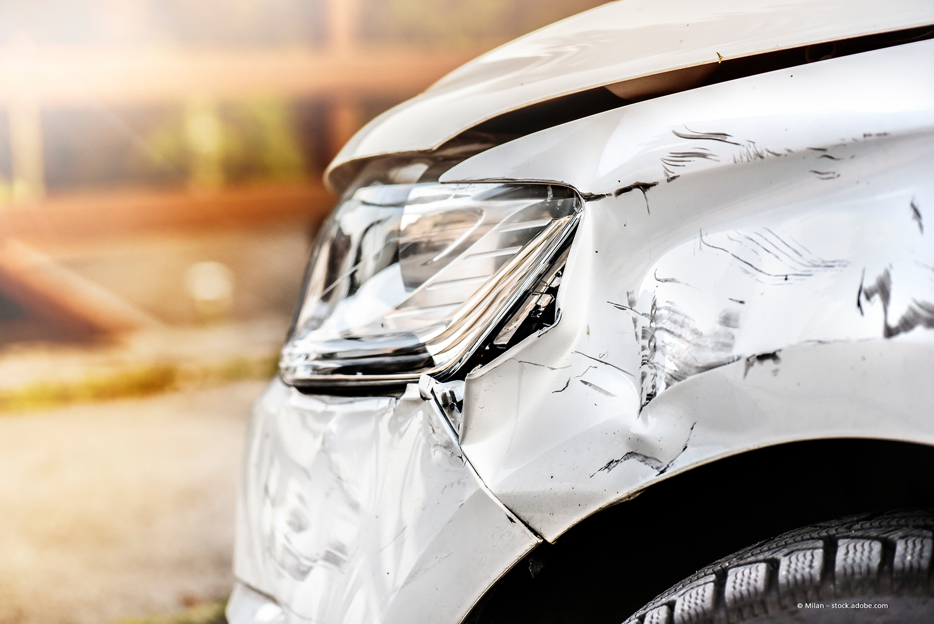 In einer hell erleuchteten Autowerkstatt werden Autos repariert; rote Hebebühnen und ein Werkzeugschrank.