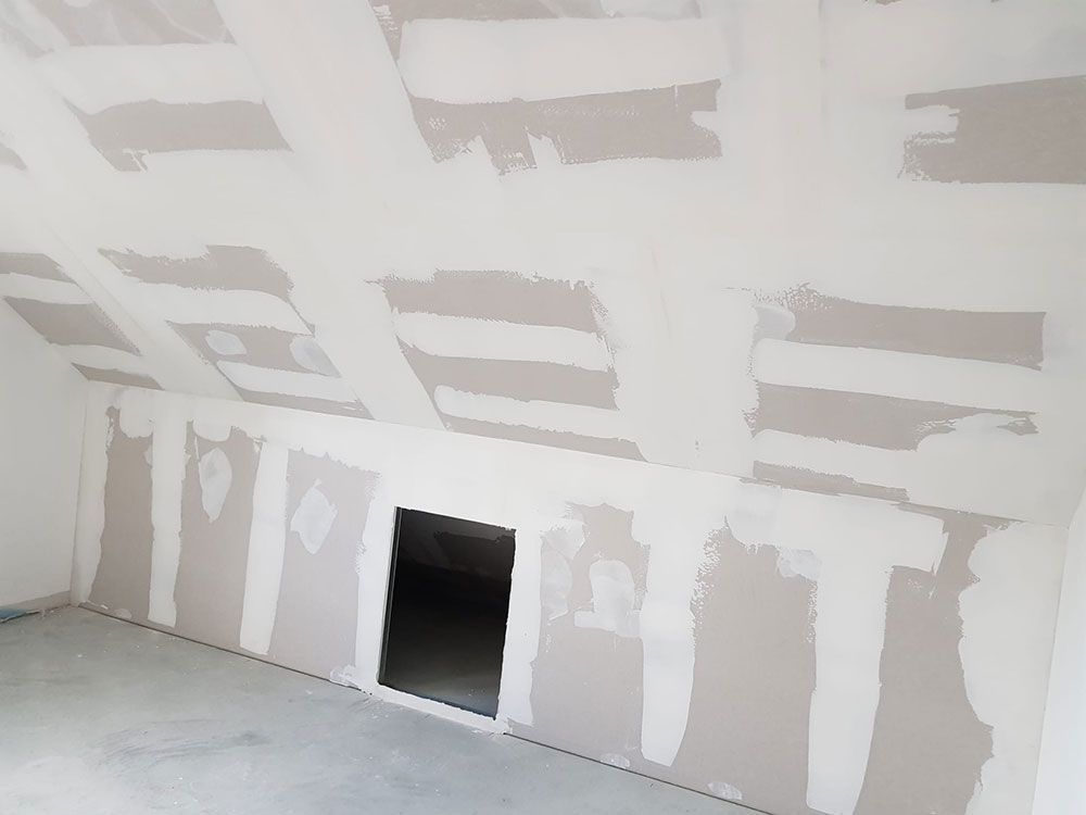 Ein Raum mit Gipskartonwänden und einer Tür in der Decke.