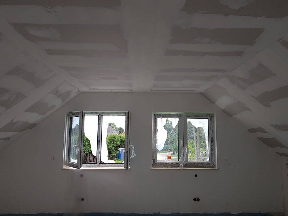 Ein Raum mit zwei Fenstern, von denen eines geöffnet ist.