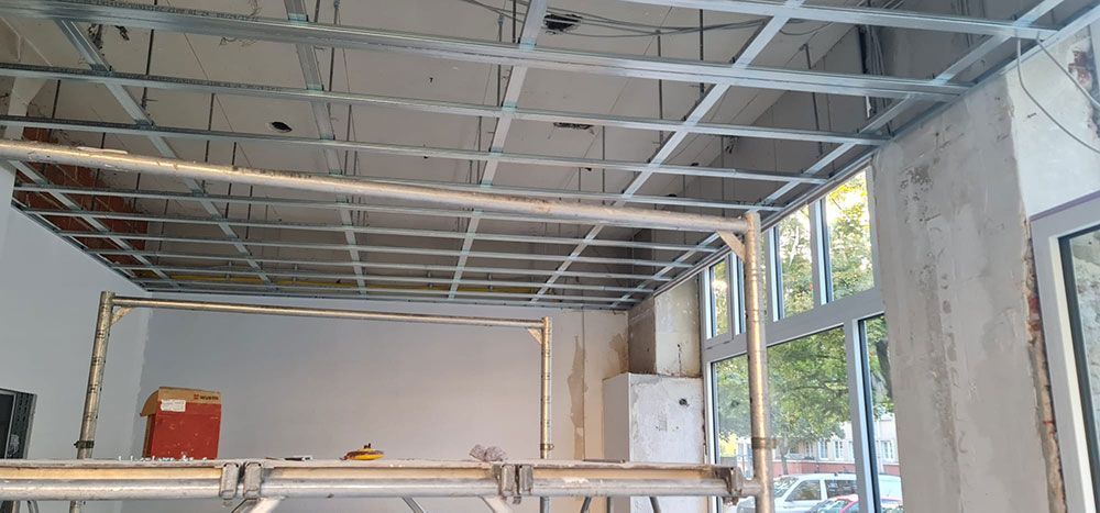 Ein Raum mit einer im Bau befindlichen Decke und einer Leiter.