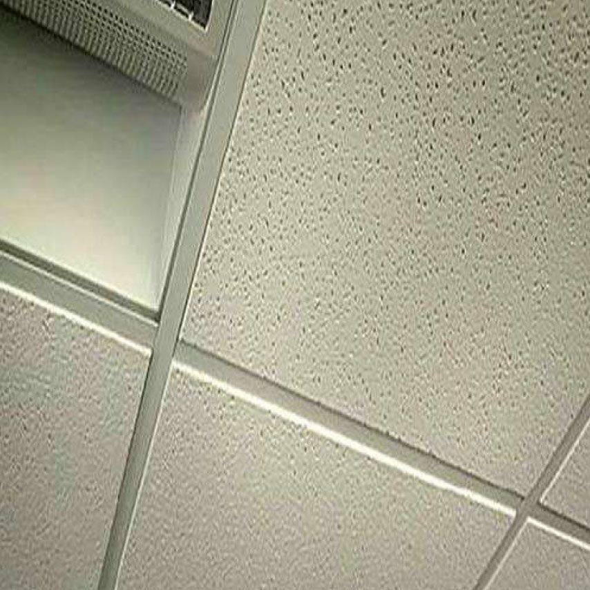 Eine Nahaufnahme einer gefliesten Decke mit einem Ventilator daran.