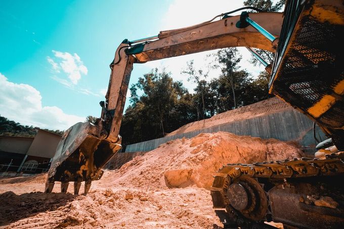 Una excavadora está moviendo tierra en un sitio de construcción.