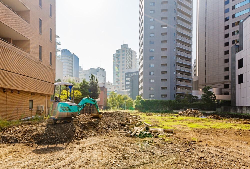 Un sitio de construcción con una excavadora en el medio.