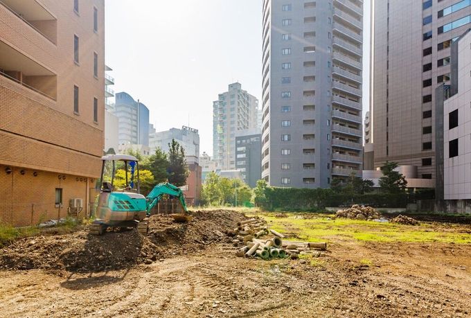 Un sitio de construcción con una excavadora en el medio.