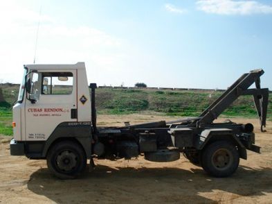 Un camión de volteo está estacionado en un campo de tierra.