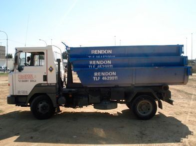 Un camión volquete Rendon está estacionado en un campo de tierra