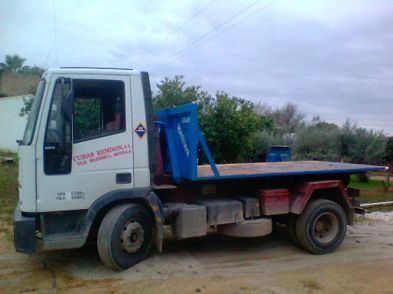 Una grúa con plataforma está estacionada al costado de la carretera.