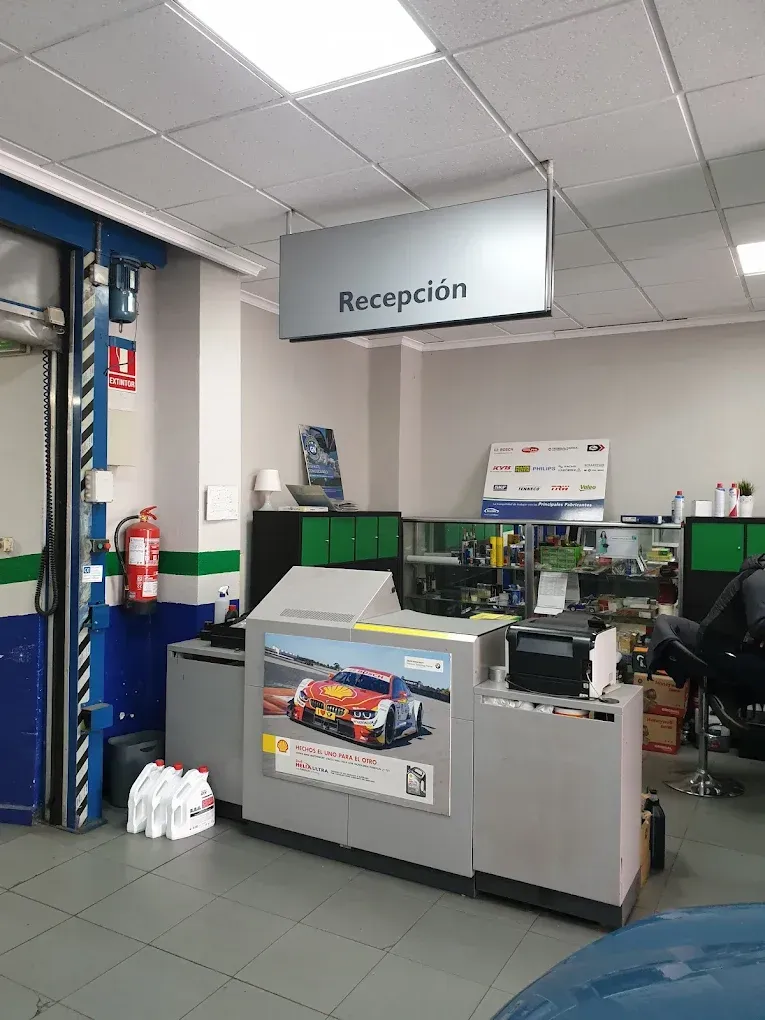 Recepción interior de un taller mecánico con un cartel que dice