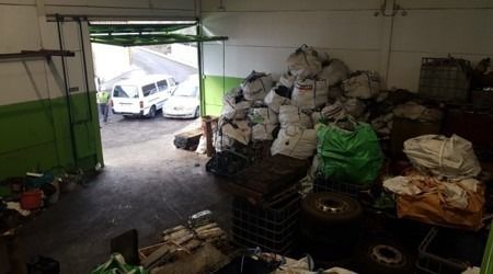 Un almacén lleno de muchas bolsas de basura y neumáticos.