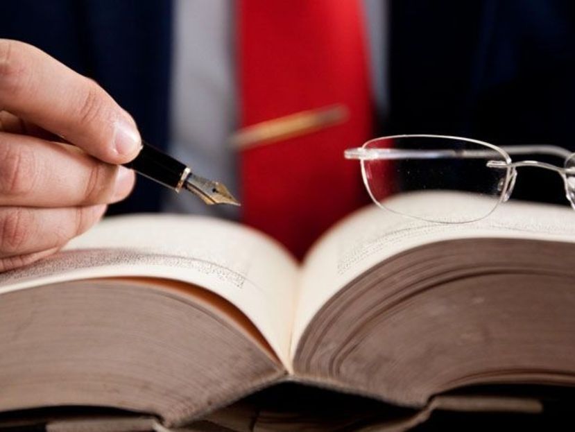 Una persona está escribiendo en un libro con una pluma fuente.