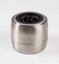 Un primer plano de un rodamiento de acero inoxidable sobre una superficie blanca.