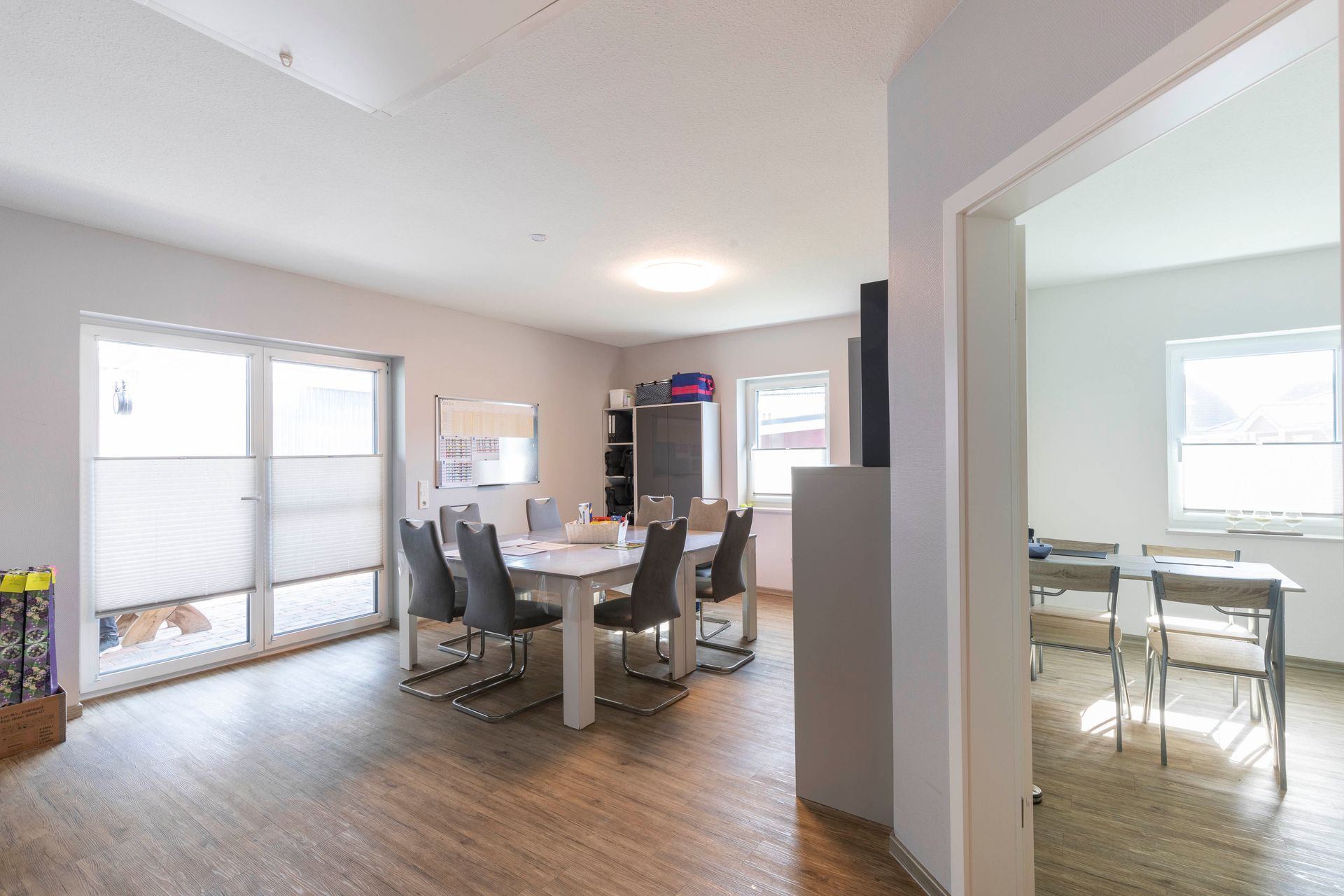 Ein Wohnzimmer mit Tisch und Stühlen und einer Tür, die zu einem Esszimmer führt.