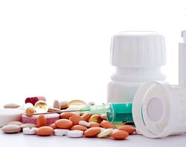 Una pila de pastillas y botellas sobre una mesa.