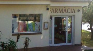 Un edificio blanco con un cartel que dice farmacia.