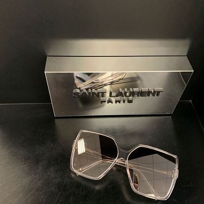 Eine Sonnenbrille liegt auf einem Tisch neben einer Kiste.