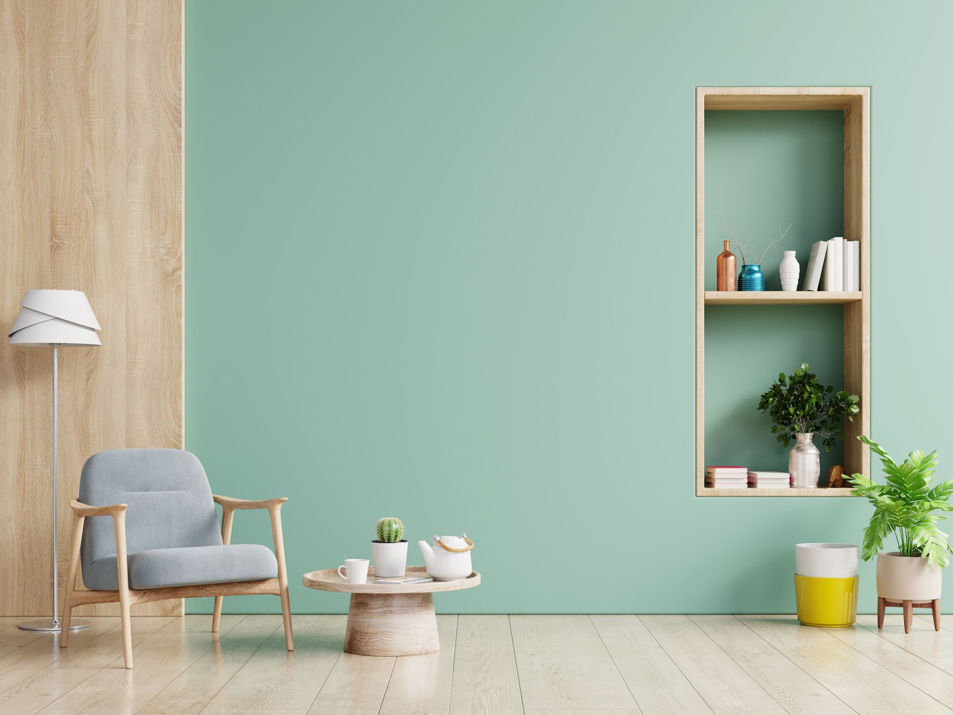 Une pièce moderne et minimaliste avec un mur vert sauge, des touches de bois clair et un fauteuil gris.