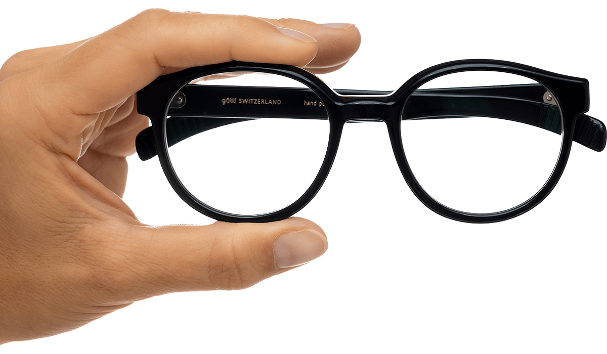 Eine Hand hält eine schwarze Brille.