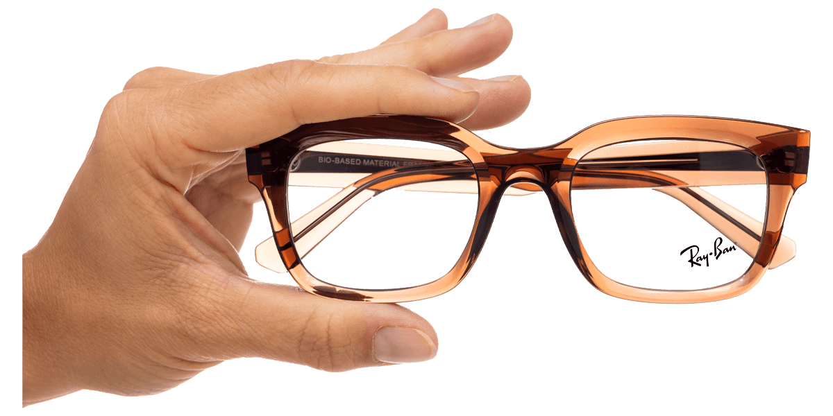 Eine Person hält eine Brille in der Hand.