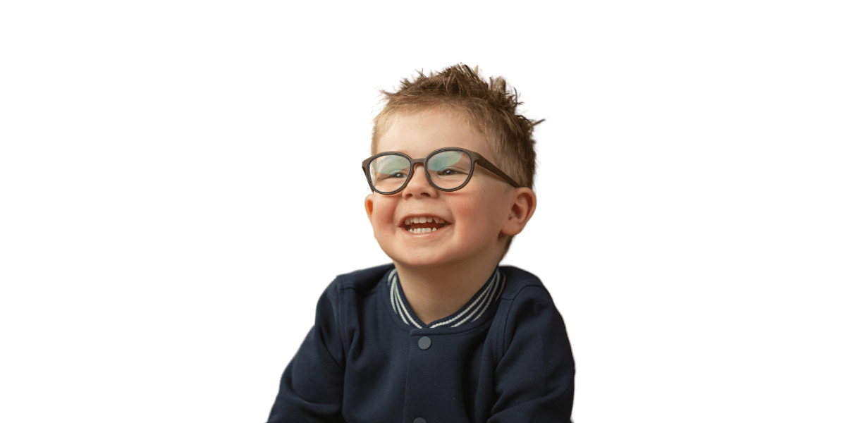 Ein kleiner Junge mit Brille und blauem Pullover lächelt.