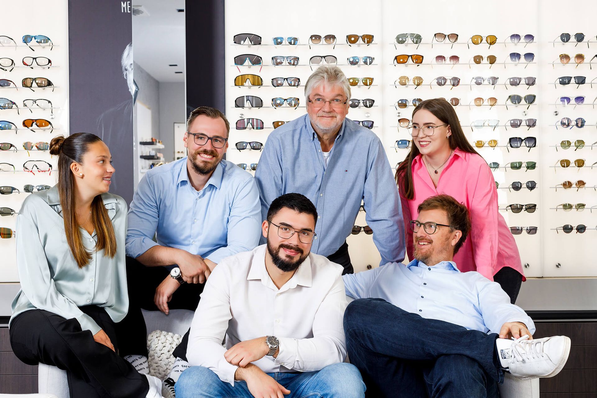 Eine Gruppe von Menschen posiert in einem Optikergeschäft für ein Foto.