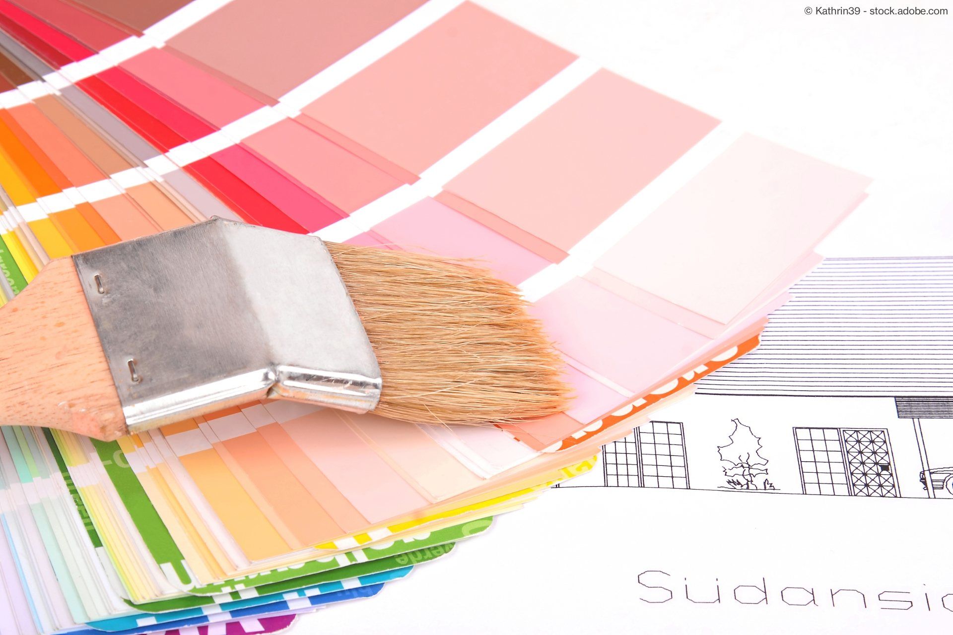 Farbproben und Pinsel auf einem Architekturplan zur Farbauswahl.