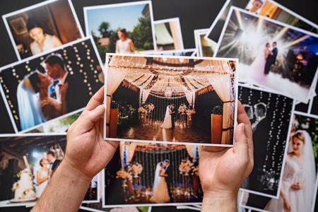 Una persona sostiene una fotografía de unos novios en su boda.