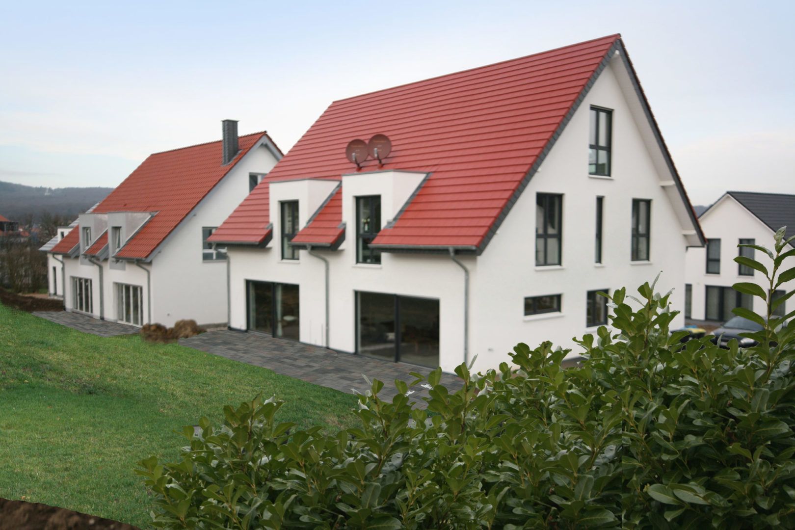 Eine Reihe weißer Häuser mit roten Dächern