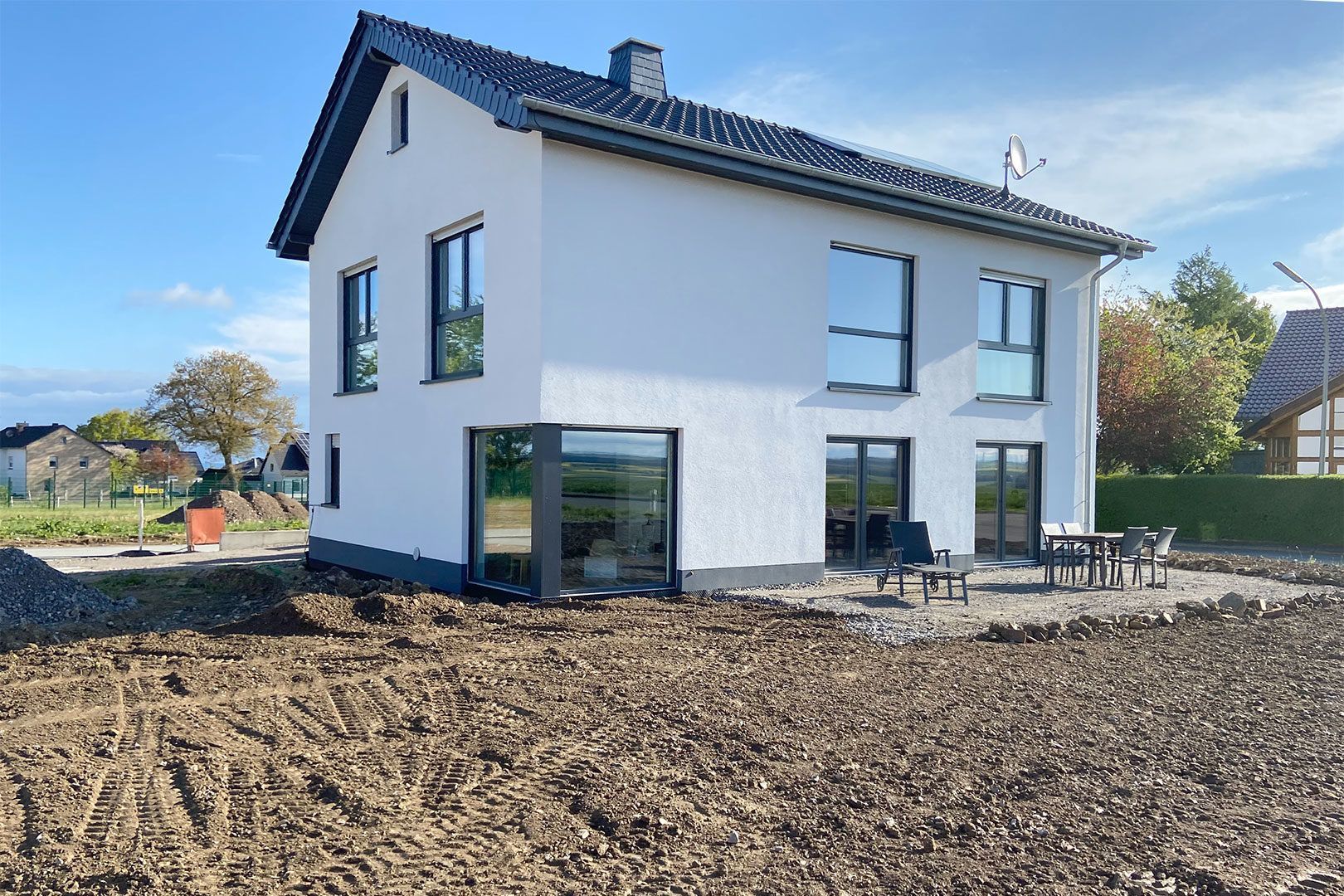 Ein weißes Haus steht inmitten eines Feldes.