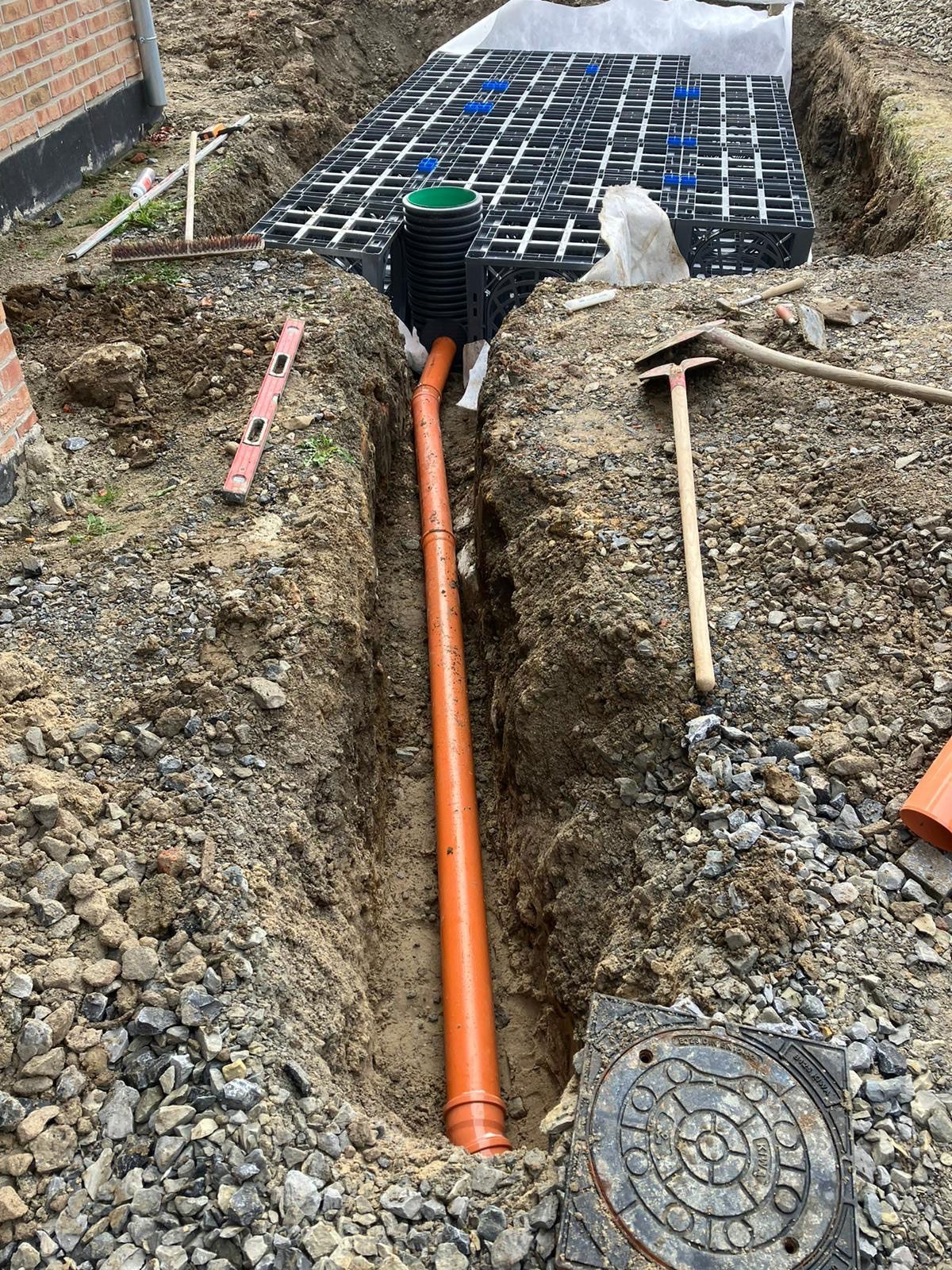 In einem Loch im Boden wird ein Rohr installiert.