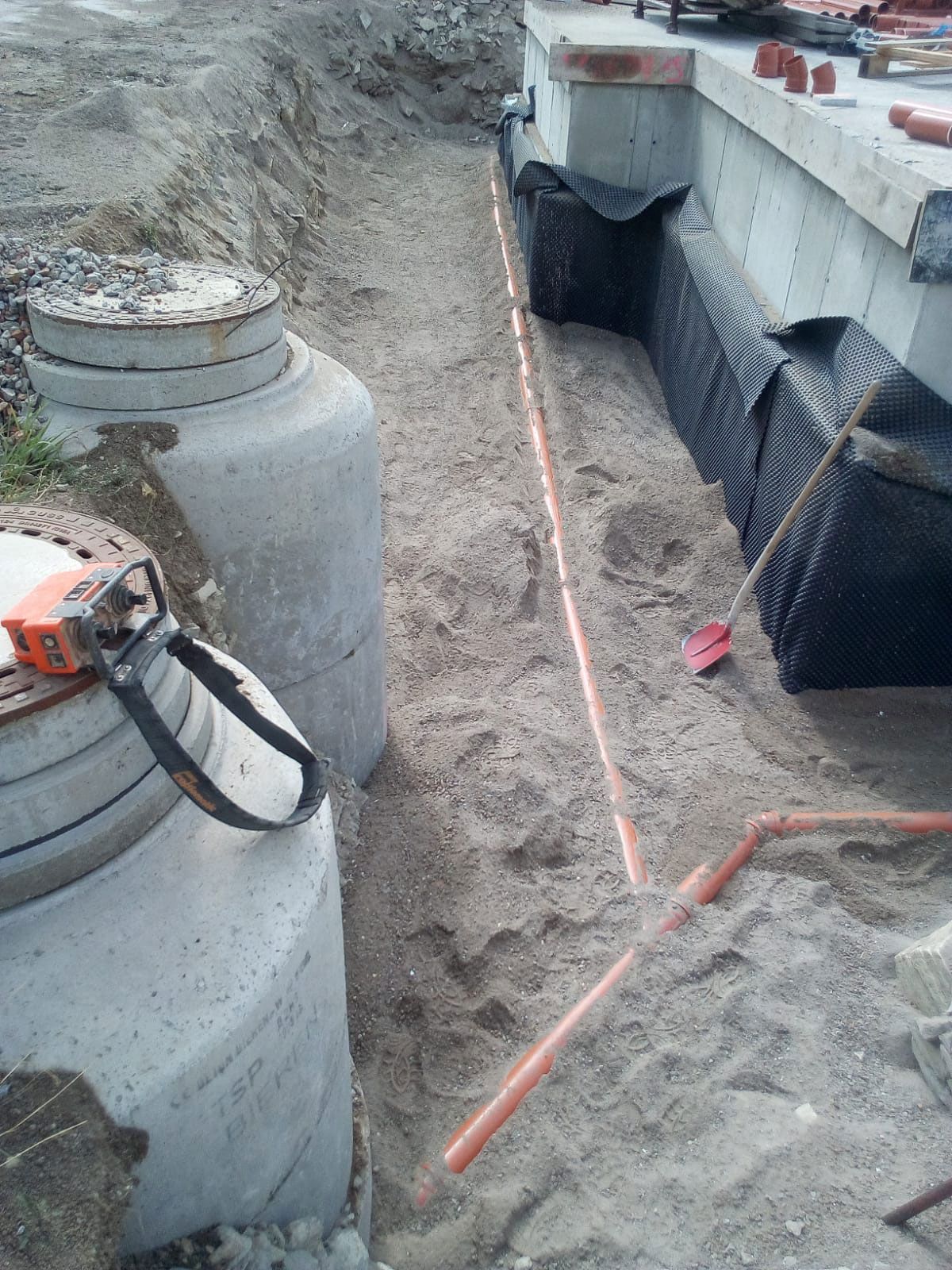 Ein Maßband liegt auf dem Boden neben einem Kanaldeckel