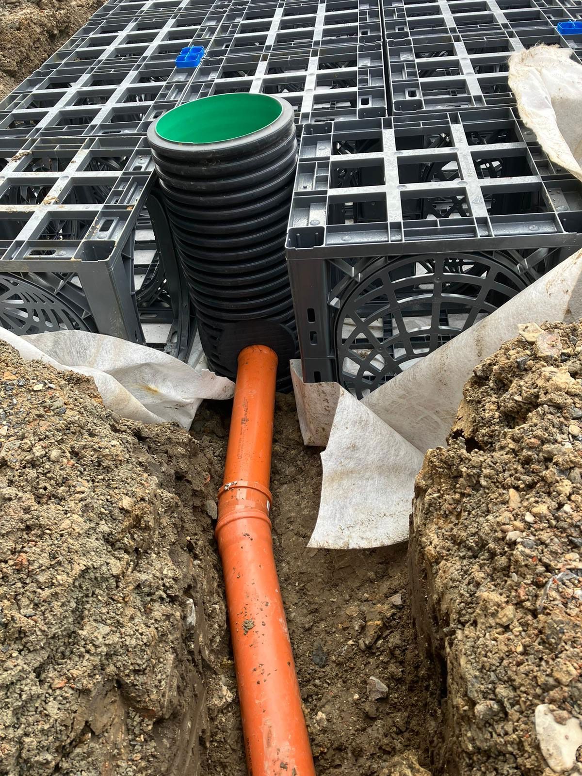 In einem Loch im Boden wird ein Rohr installiert.