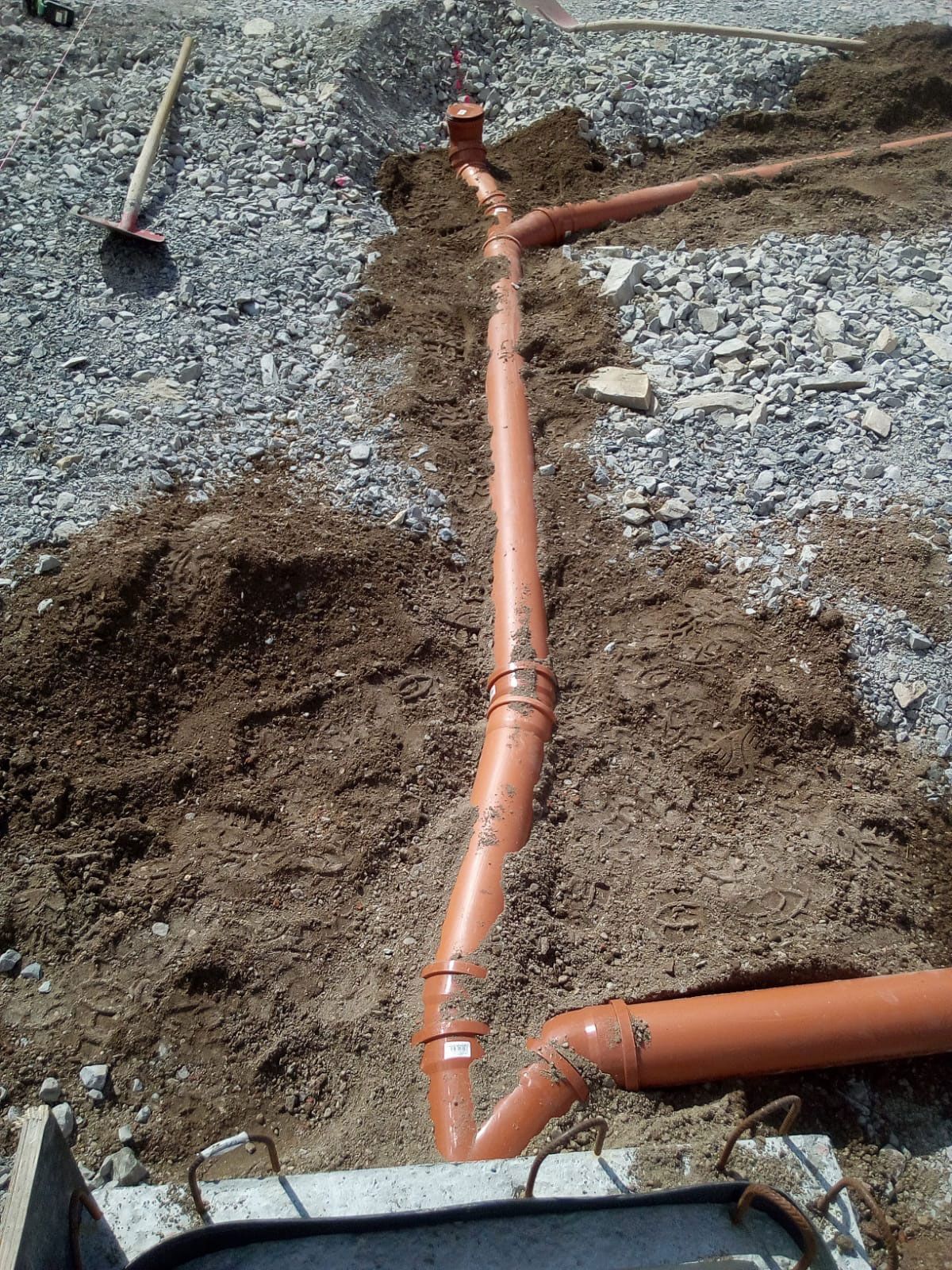 Auf einer Baustelle liegen mehrere Rohre im Boden.