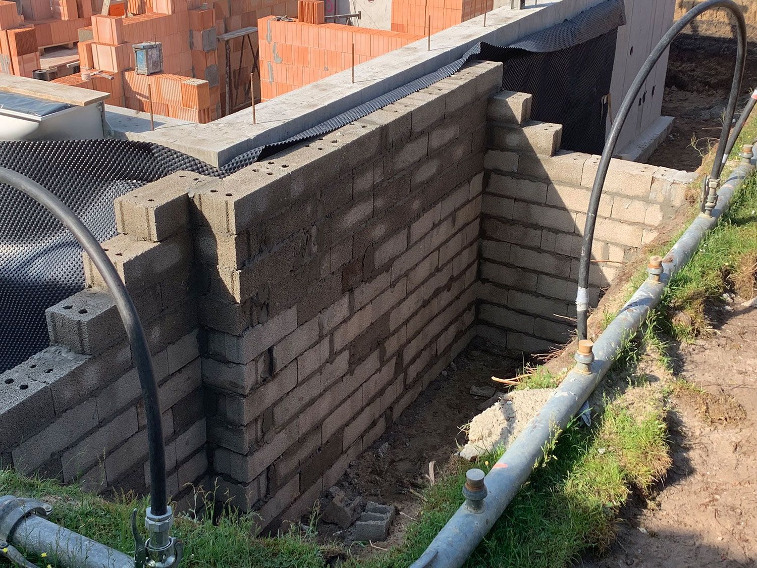 Auf einer Baustelle wird eine Ziegelmauer gebaut.