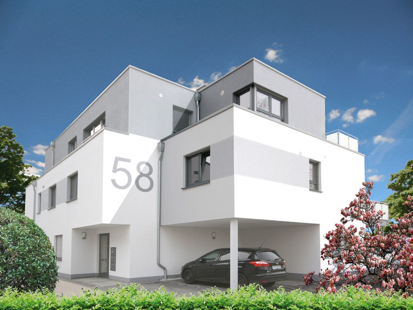 Vor einem weißen Gebäude mit der Nummer 58 parkt ein Auto.