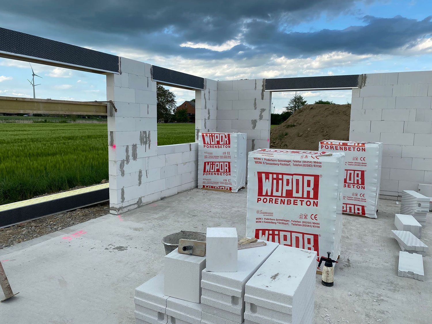 Ein im Bau befindliches Gebäude mit vielen Ziegeln auf dem Boden.